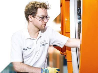 Man in goggles looking into mouth of machinery