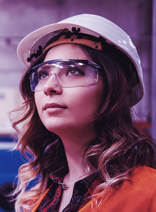 Young female engineer in safety glasses and hard hat