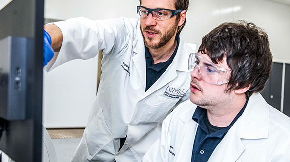 Student and professor looking at a computer monitor