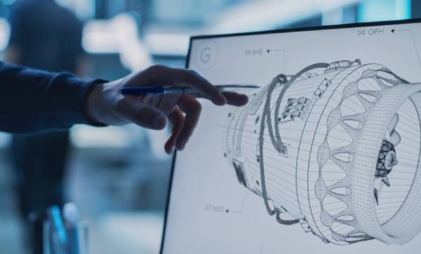 Man pointing at 3d model of aero engine on screen